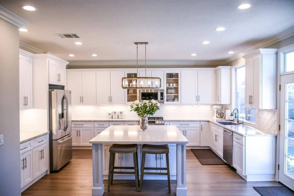 Big white kitchen with white kitchen island and stainless steel appliances