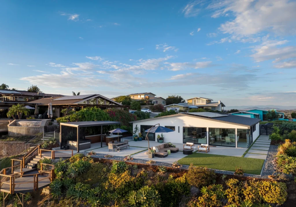 Backyard patio of a Pacific Beach midcentury modern home with sliding glass doors opening to outdoor living space