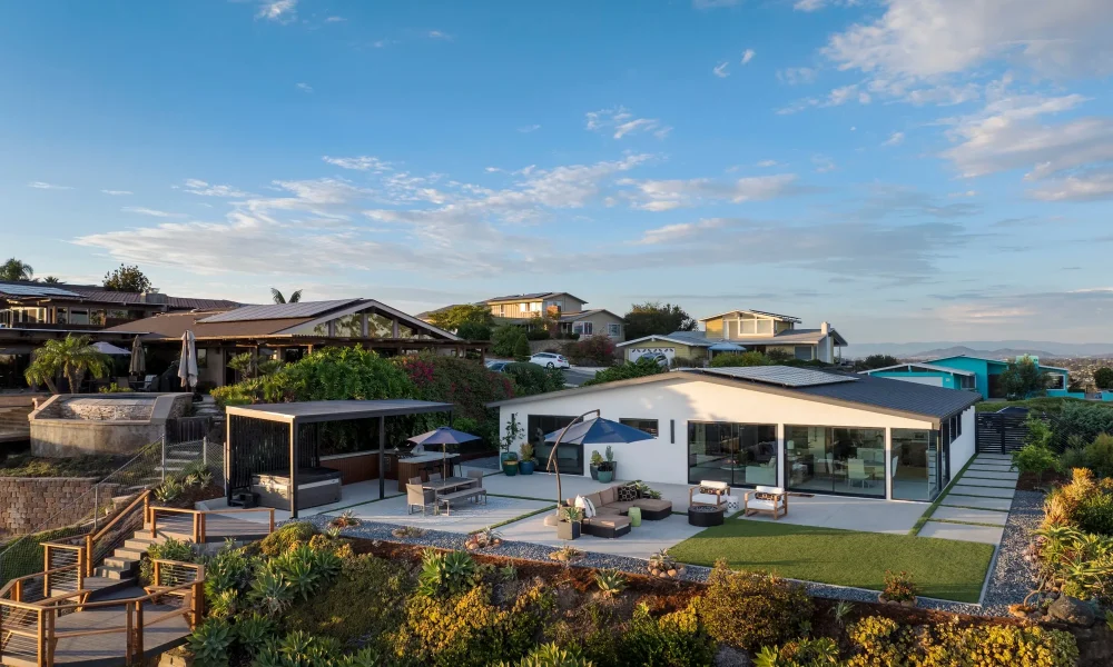 Backyard patio of a Pacific Beach midcentury modern home with sliding glass doors opening to outdoor living space