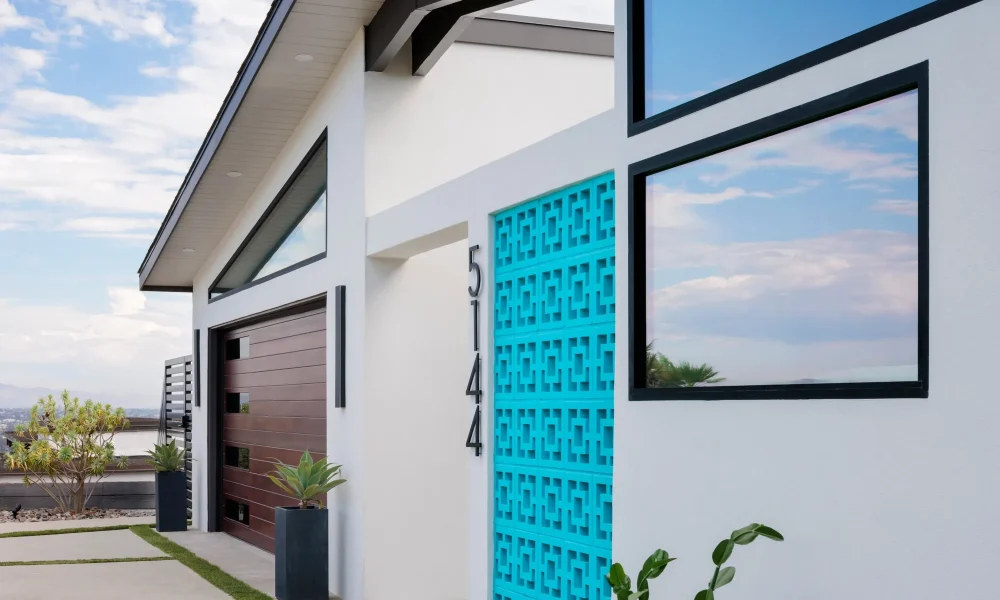 Turquoise breeze block entry and black-framed windows on a renovated Pacific Beach midcentury modern home
